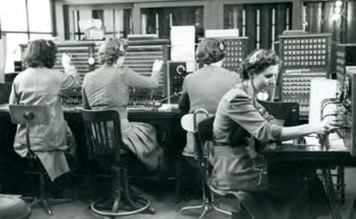BR_VOORSTRAAT_182 De telefoondienst in het postkantoor van Brielle, dames zitten achter de posten; April 1951