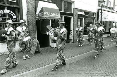 BR_VOORSTRAAT_529 Tijdens de Kolder Koopavond loopt een fanfare door de Voorstraat langs Café Bar De Knijp; 3 juli 1986
