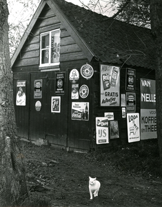 NH_DUINWEG_010 Een schuur die volgehangen is met reclameborden; 13 december 1960