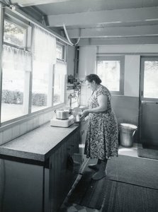 RO_OVERIG_01 Een huisvrouw staat in de keuken bij haar elektrische kookplaat (reclame ATAG ?); 1959