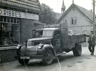 RO_PERSONEN_158 De heer W. van Rij bij een wagen met puin (Wegtransport van A.J. v/d Nol Rockanje) voor de winkel van ...