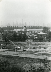 SP_MOLEN_027 De molen Nooitgedacht, met op de voorgrond de bouwput voor het nieuwe centrum en op de achtergrond Shell; 1980