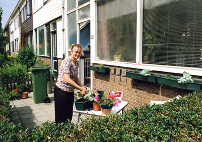 SP_WIJKEN_VOGELBUURT_001 Een bewoonster vult bloembakken met planten; ca. 1997