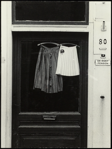 FOTO_GF_C107 Twee rokken hangen te drogen in de deuropening van Pension De Roef; 1962