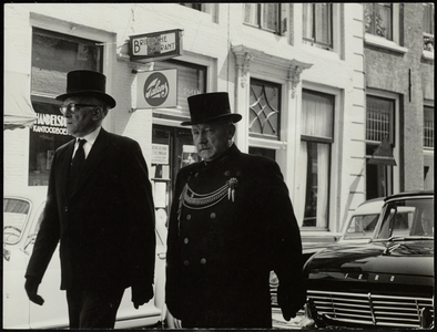 FOTO_GF_C130 Een begrafenisstoet met voorop P. van Adrighem en Van Hoogstraten passeert op straat; 1962