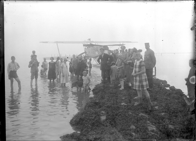 GN2335 Talloze badgasten hebben zich verzameld rond een watervliegtuig op de vloedlijn; ca. 1925
