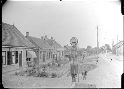 GN2493 Straatbeeld met onder meer een benzinepomp en een hond; ca. 1925