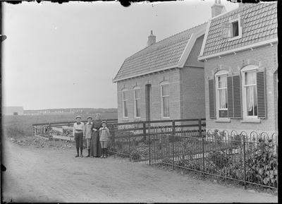 GN2606 Moeder met drie kinderen poseert voor een huis; ca. 1925