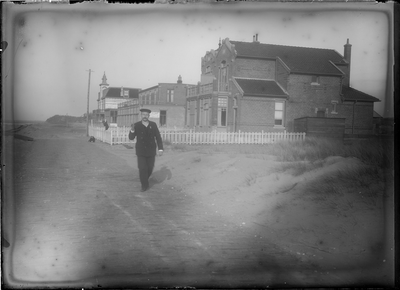 GN2609 Een man in uniform loopt over de Boulevard in Oostvoorne; ca. 1920