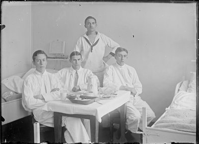 GN2800 Vier matrozen rond een tafel met eten, een bed; ca. 1910