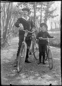 GN2874 Een militair in uniform en een jongen met allebei een fiets aan de hand; ca. 1910