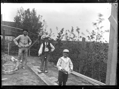 GN3062 Twee mannen en een jongen in de tuin om een muur te metselen; ca. 1912