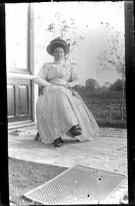 GN4018 Een vrouw op een stoel naast een serre (waarschijnlijk in Villa Anna); ca. 1912