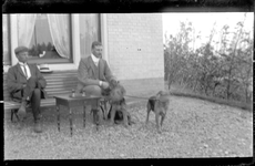 GN4023 Twee mannen op een tuinbank met twee honden (mogelijk familie Boers); ca. 1915