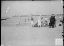 GN5002 Kijkje op het strand van Oostvoorne. Een veerboot heeft aangelegd bij het steiger; ca. 1920