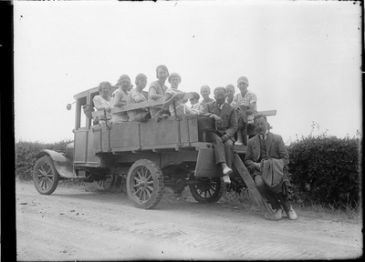 GN5028 Een groepje personen op een vrachtwagen; ca. 1920