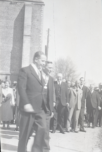 B1090 Een stoet hoogwaardigheidsbekleders loopt langs de kerk, waaronder de burgemeester; ca. 1950