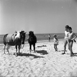 C1272 Badgasten vermaken zich op het strand; 10 augustus 1959