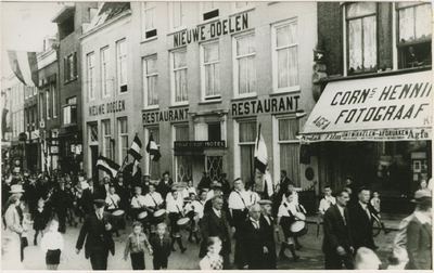 A-1304 Muziekkorps op de Markt te Middelburg, ter hoogte van hotel-restaurant Nieuwe Doelen en de winkel van fotograaf ...