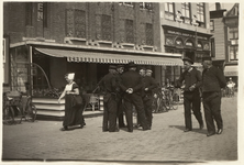 A-194 Vrouw en mannen in Walcherse en Zuid-Bevelandse klederdracht voor de bioscoop Electro op de Grote Markt te Middelburg