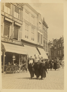 A-463 Drie vrouwen in Walcherse dracht op de Grote Markt te Middelburg, achter de gevels van restaurant de Nieuwe ...