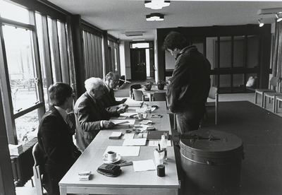 B-1600III Stembureau voor de verkiezingen van de Gemeenteraad van Middelburg, melden aan de tafel