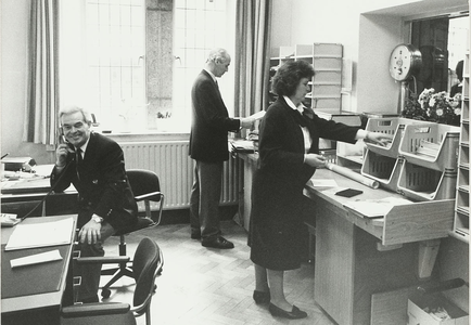 B-1602B De bodenkamer van het stadhuis van Middelburg, met zittend, dhr C. Joosse, staand dhr C.M. van Raaij en mevr. ...