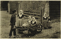 P-1269 Zeeland (Walcheren). Een jongen en een aantal meisjes in dracht op een handkar.