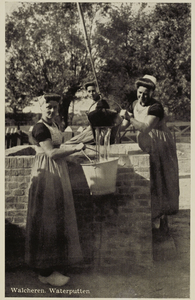 P-1323 Walcheren. Waterputten. Drie vrouwen in dracht aan het waterputten.