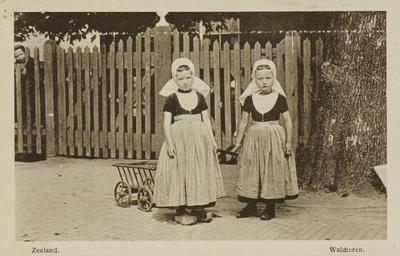 P-1349 Zeeland. Walcheren.. Twee meisjes in Walcherse klederdracht met een bolderkar.