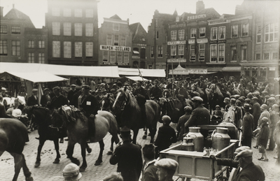 P-1412 Ringrijders op de markt te Middelburg. Op de voorgrond een kar met enkele melkbussen.