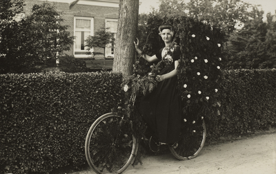 P-1676 Vrouw in Walcherse dracht poseert met een versierde fiets tijdens de festiviteiten rond de installatie van ...
