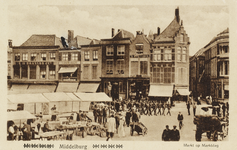 P-595 Middelburg Markt op Marktdag. Gezicht op de Grote Markt te Middelburg met marktkramen en marcherende soldaten. ...