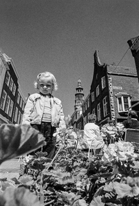 214 Een meisje bij een bloemenbak op de Markt te Middelburg