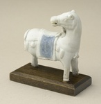 246 Blanc de Chine beeldje van een paard, de tas blauw gedecoreerd. Afkomstig uit het wrak van het schip de Geldermalsen