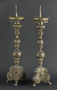65 Twee kraagkandelaars van geel koper (messing), gebruineerd, 17de eeuw. De kandelaars bestaan uit een achtkantige ...