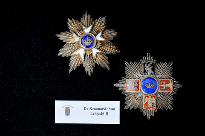 51 Medaille de Kroonorde. De medaille rechts wordt met een paars lint om de hals gedragen. Niet zeker is of de ster ...