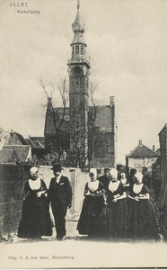 2024 Veere Kerkuitgang. Een groep vrouwen in Walcherse dracht, met kerkboek onder de arm, in het Simon Oomstraatje te ...