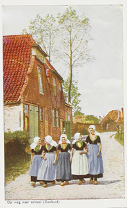 2033 Op weg naar school (Zeeland). Een groep meisjes in Walcherse dracht in de Wagenaarstraat te Veere
