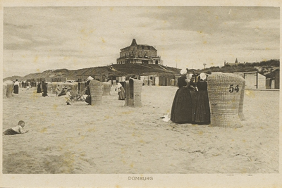 2066 Domburg. Gezicht op het strand van Domburg met opgestelde rieten strandstoelen. Op de top van een duin het Strandhotel