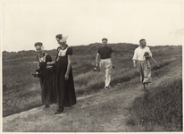2405 Golfspelers op de golfbaan te Domburg met twee meisjes in Walcherse klederdracht, die de caddy's dragen