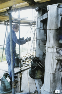 243 Een man bezig met werkzaamheden aan de klokken van het carillon van het Stadhuis te Veere tijdens de restauratie