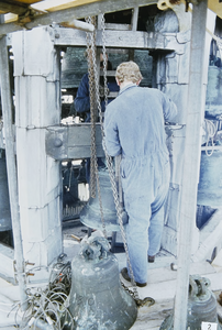244 Een man bezig met werkzaamheden aan de klokken van het carillon van het Stadhuis te Veere tijdens de restauratie