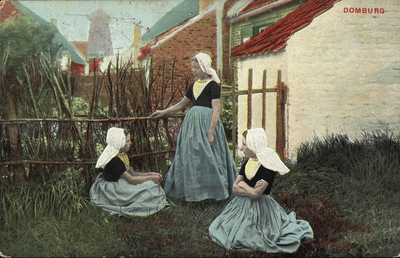 2710 Domburg. Drie meisjes in dracht in een tuin te Domburg