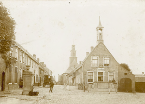 2174 Gezicht in het dorp Biervliet, met raadhuis, op de achtergrond de Nederlandse Hervormde kerk, en personen