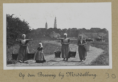 3-30 Vrouwen en meisjes met juk en melkemmers op de Breeweg te Koudekerke met op de achtergrond Middelburg