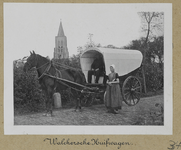 3-34 Walcherse huifkar met echtpaar in klederdracht, met daar achter de toren van de Nederlandse Hervormde kerk te ...