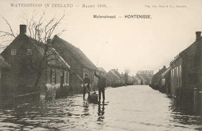 377-54 Watersnood in Zeeland - Maart 1906.. Gezicht in de overstroomde Molenstraat te Hontenisse met twee personen op ...