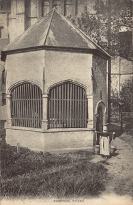 10010 Fontein, Veere. De cisterne bij de Grote Kerk te Veere aan de Oudestraat met een vrouw in klederdracht met juk en ...
