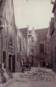 10677 Gezicht in de Kuiperspoort te Middelburg, met links personen, met flessen wijn